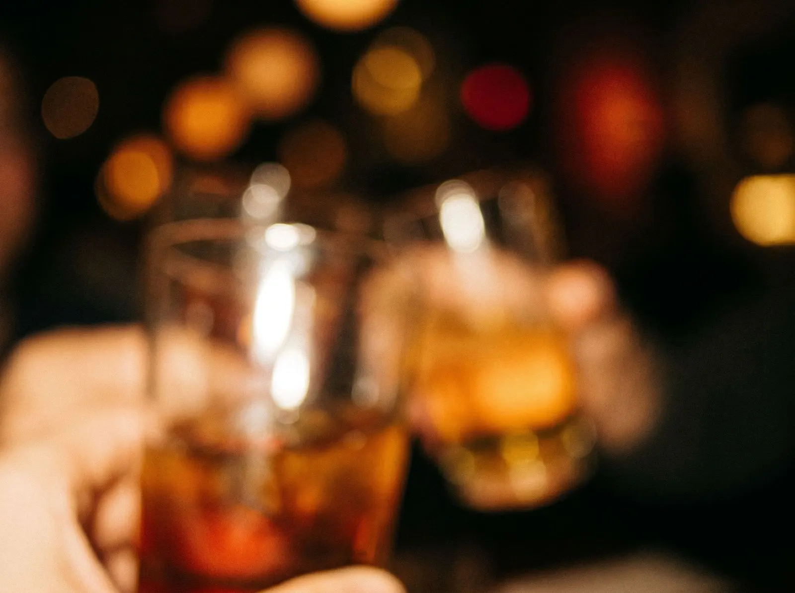 Warm bokeh and wine glasses, dim restaurant